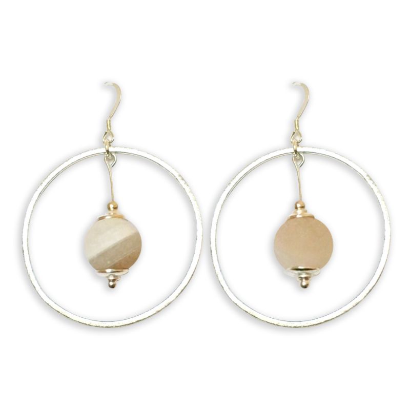 A pair of circular earrings with a beige stone in the center.