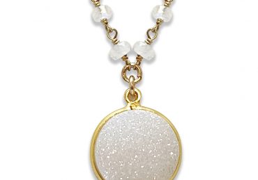 A round white druzy pendant necklace with gold trim.