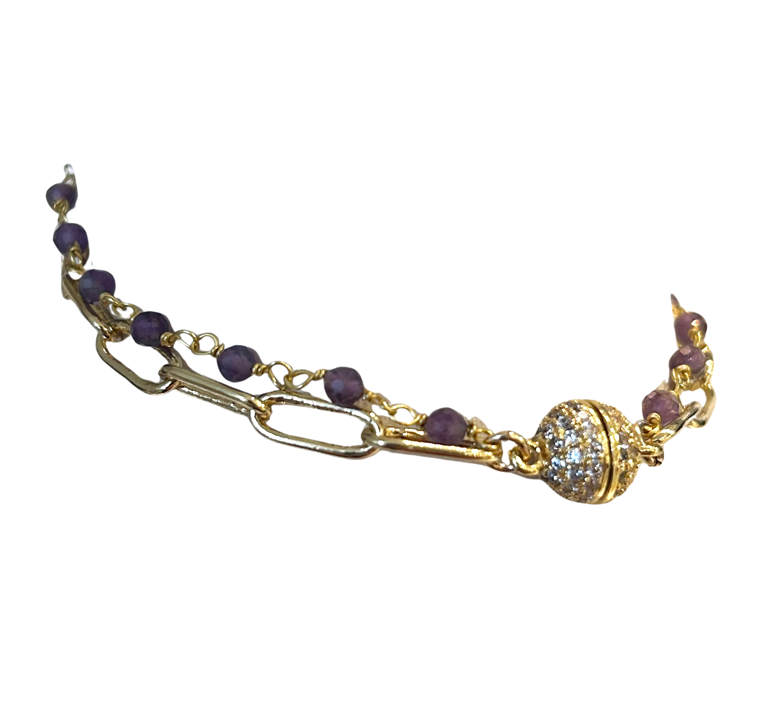 An ornate gold bracelet with purple beads and a large central crystal.